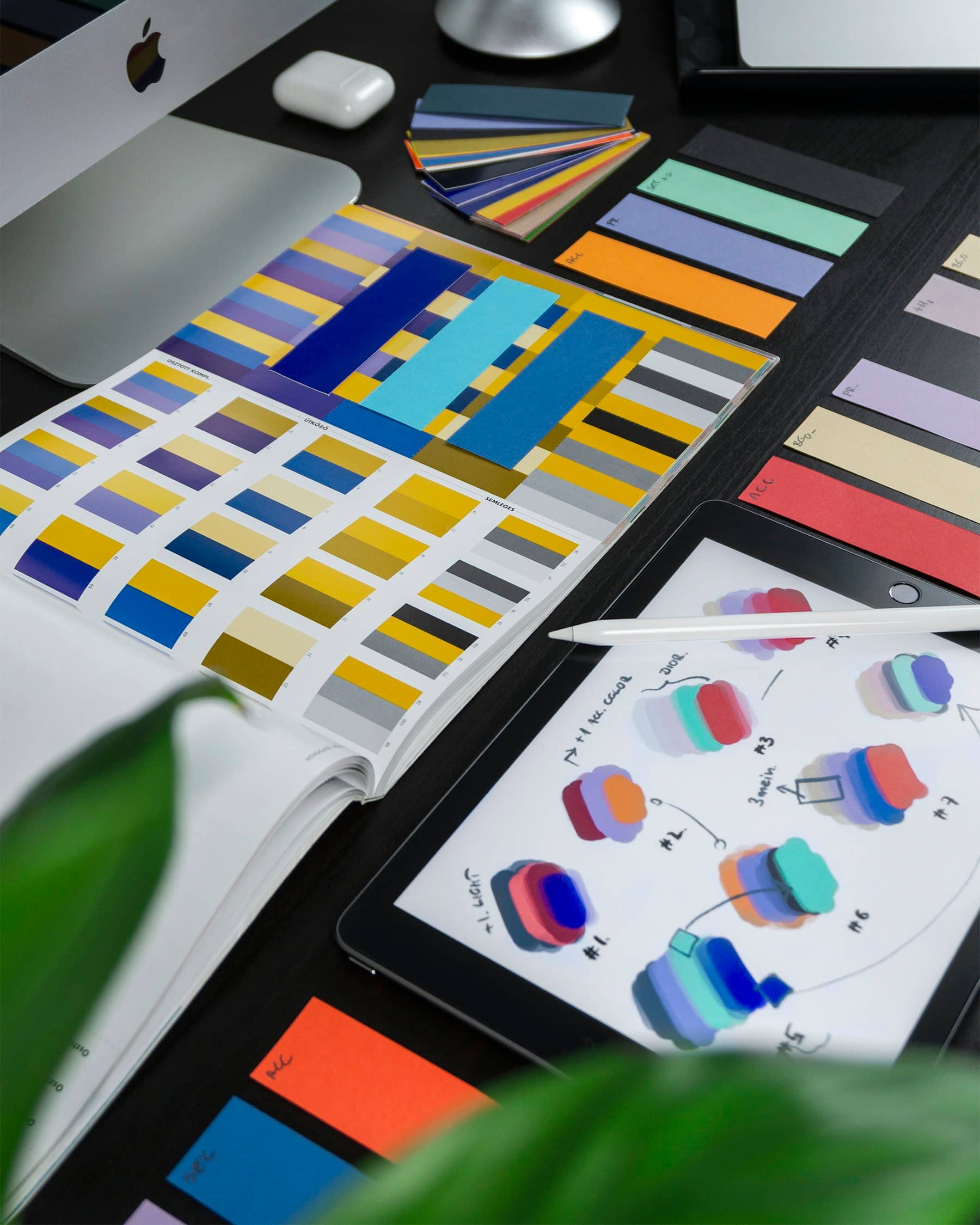 Color swatches and printed brand concepts spread on a desk