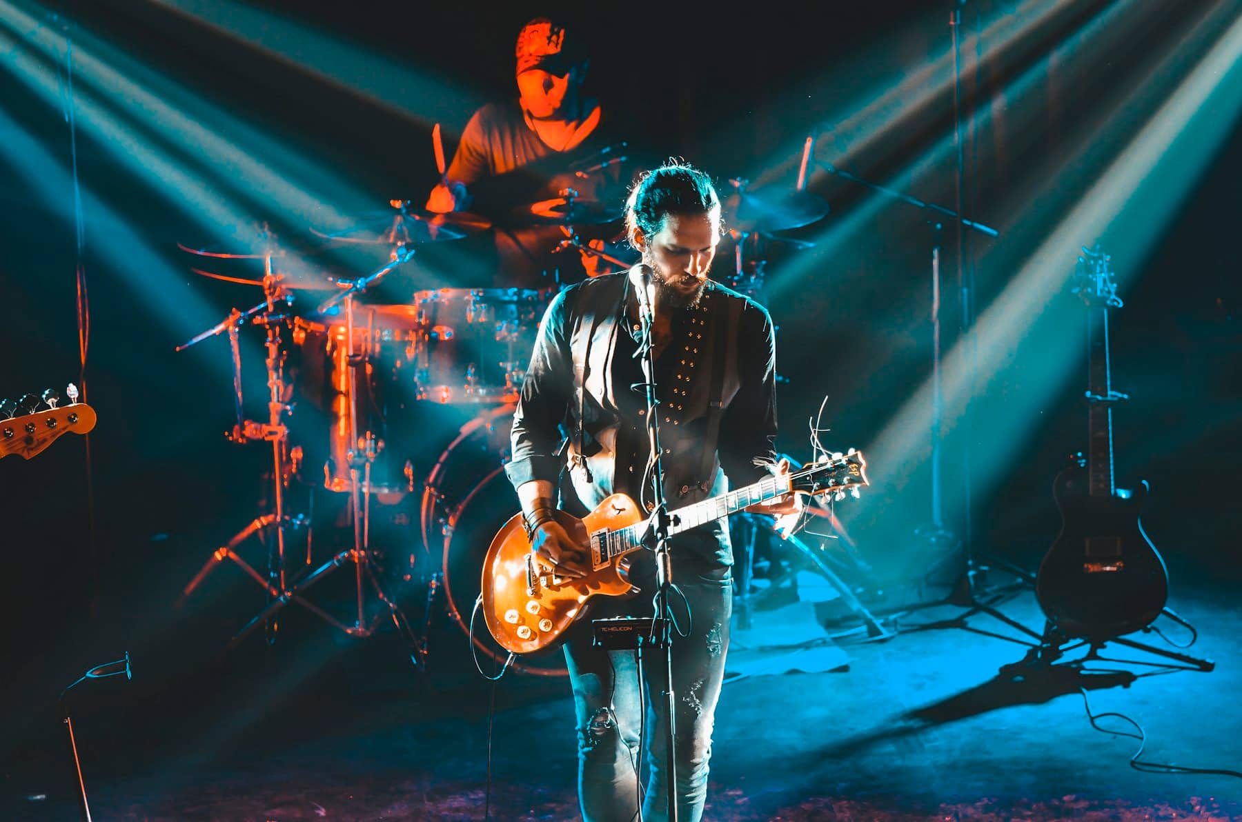 Guitarist performing under blue stage lights