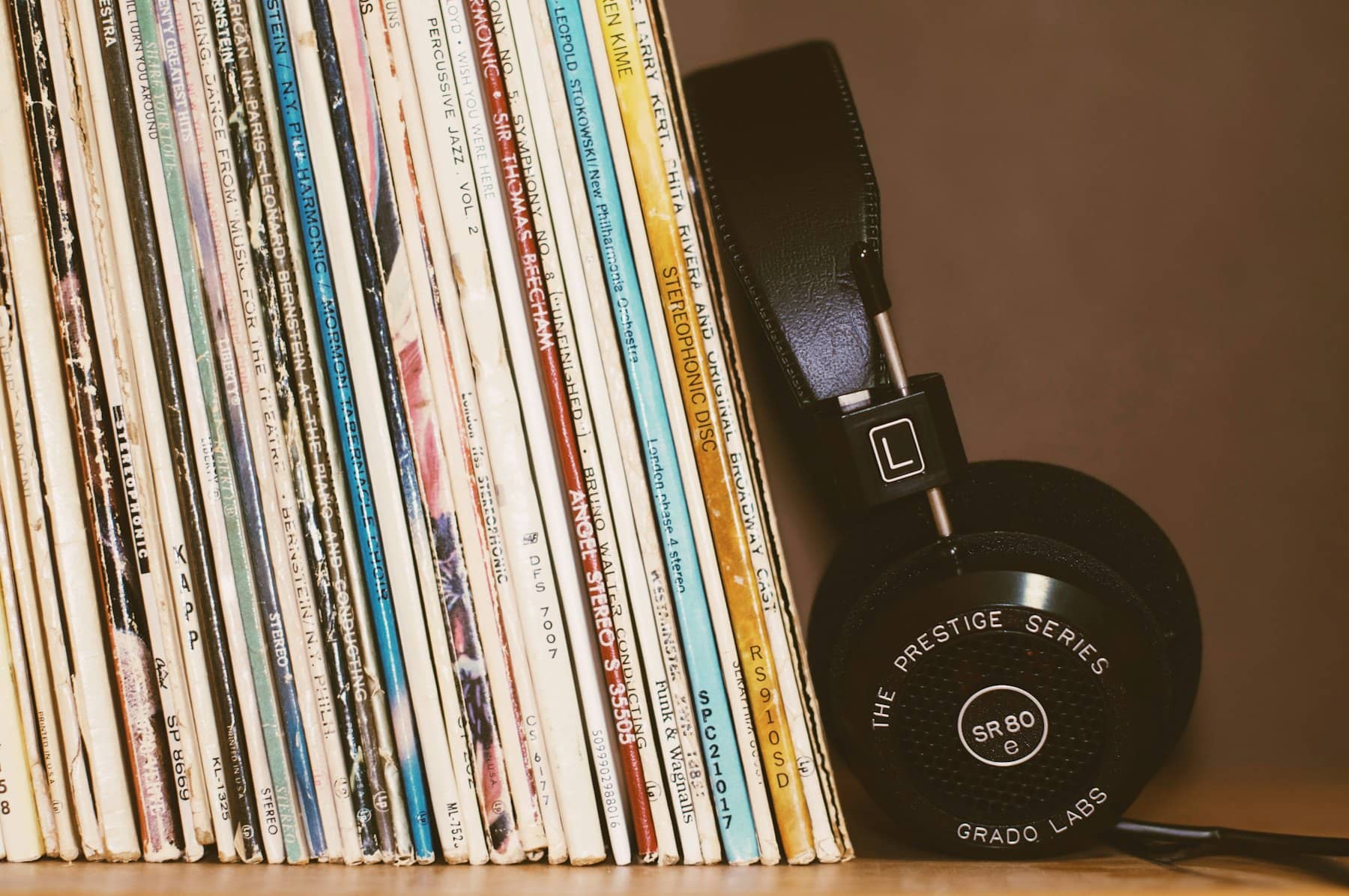 Vinyl records lined up beside studio headphones